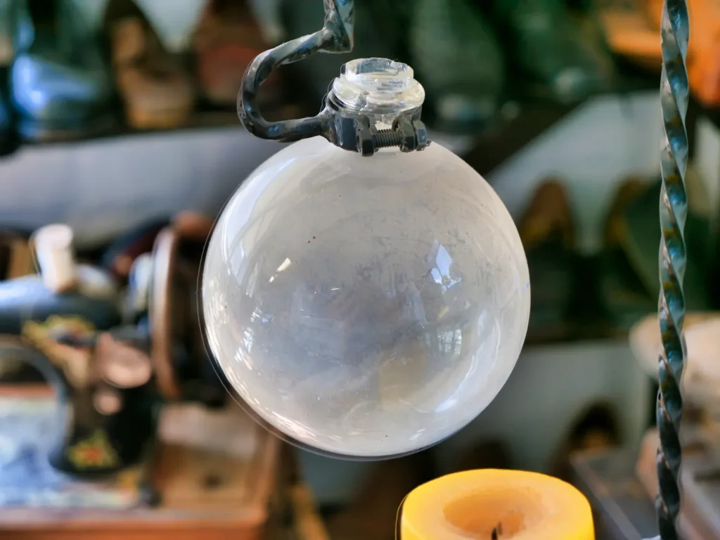 Vintage-Schuhsterkugel mit gedrehtem Textilkabel in einer Museumsausstellung - historische Beleuchtung als dekoratives Element im Schuhmuseum.