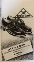 Produktfoto schwarzer Kinderschuhe der Marke "OKE Kinder-Schuhe" mit Visitenkarte von "Ott & Sohn Kinderschuhfabrik" aus Materborn.