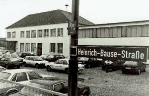 Historisches Schwarz-Weiß-Foto eines Industriegebäudes an der Heinrich-Bause-Straße mit parkenden Autos aus den 1970er oder 1980er Jahren